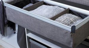 Divided closet drawer containing sweaters